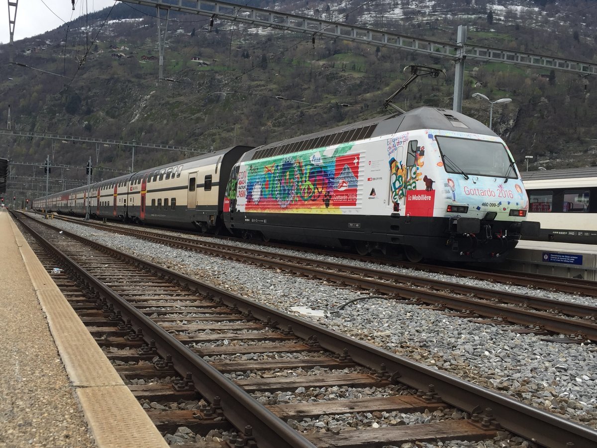 Re 460 099 mit Mobiliar / Gottardo 16 Werbung am 9.4.16 im Bahnhof Brig.