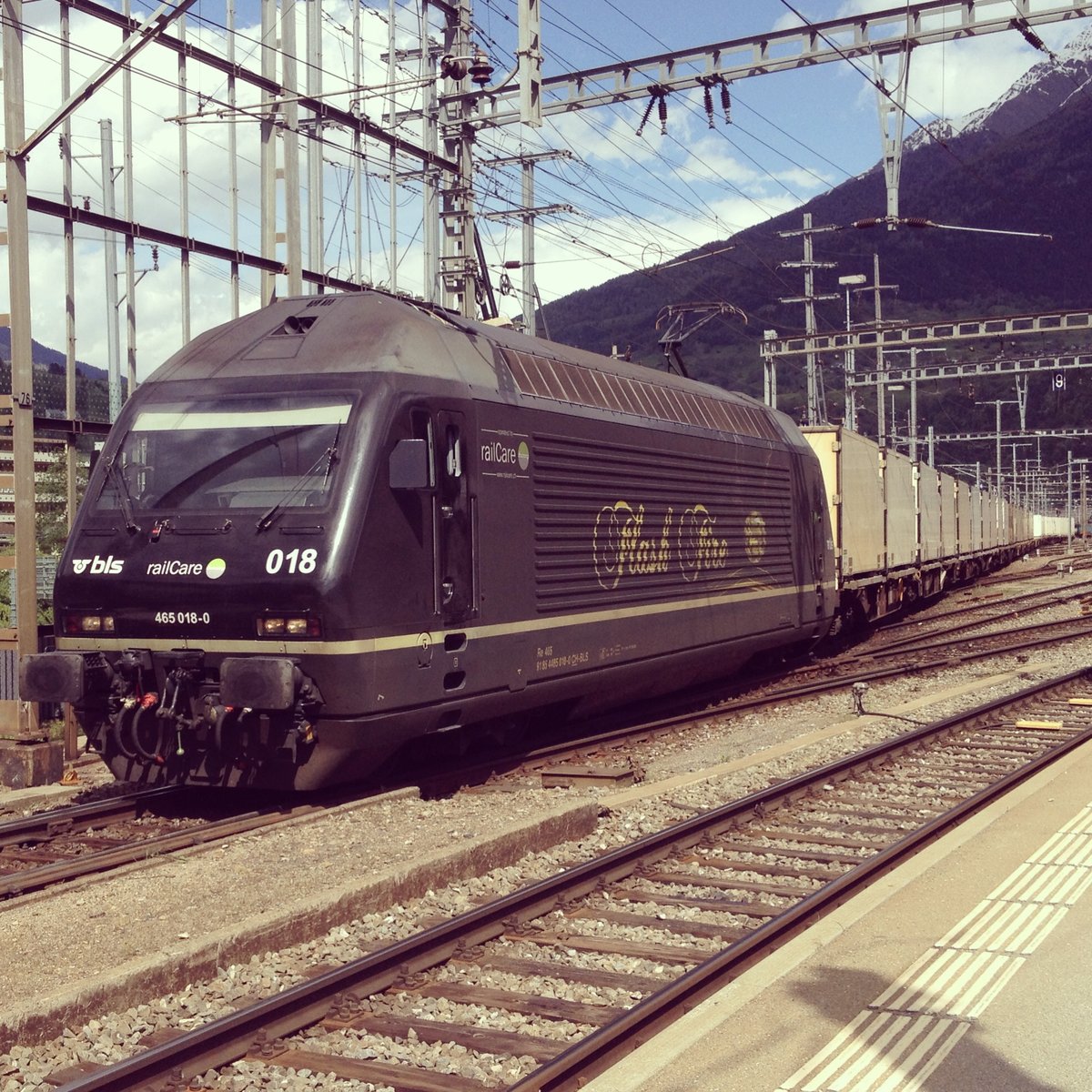 Re 465 018  Flash Fire  im Dienste der RailCare beim verlassen von Brig, am 9.5.14.