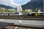 Der RBDe 560 221 der SBB und der ABt 954 von RegionAlps mit Kanal 9 Vollwerbung am 8.8.23 beim Bahnhof Brig.